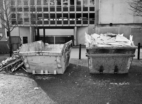 Workers loading waste into a skip for disposal